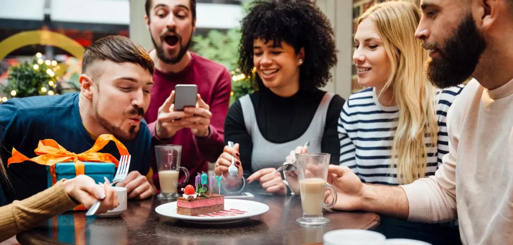 Group of friends celebrating a birthday at a restaurant.